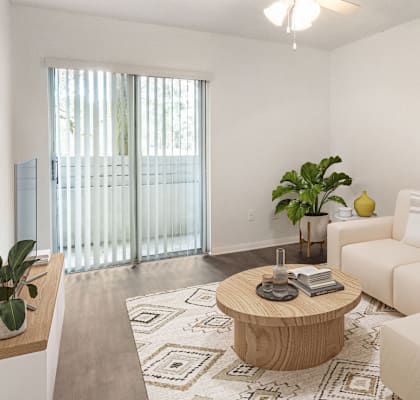 A living room with a white couch, a coffee table, and a plant.