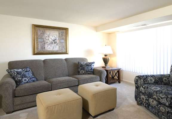 a living room with a couch and chairs and a window