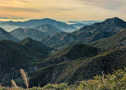 A mountain range with greenery and a clear sky.