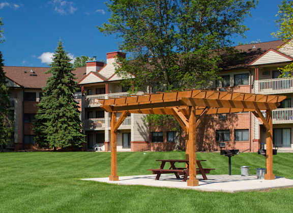 a picnic area in the middle of a yard in front of an apartment building
