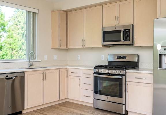 A kitchen with wooden cabinets and stainless steel appliances.