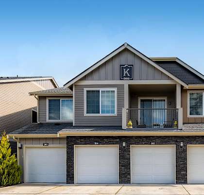 A house with a garage and a driveway in front.