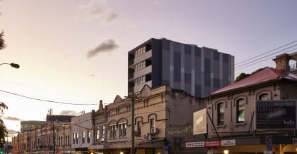 a city street at dusk with a tall building