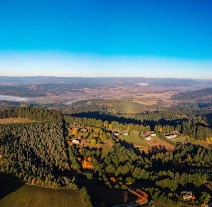 A rural landscape with a mix of greenery and buildings.