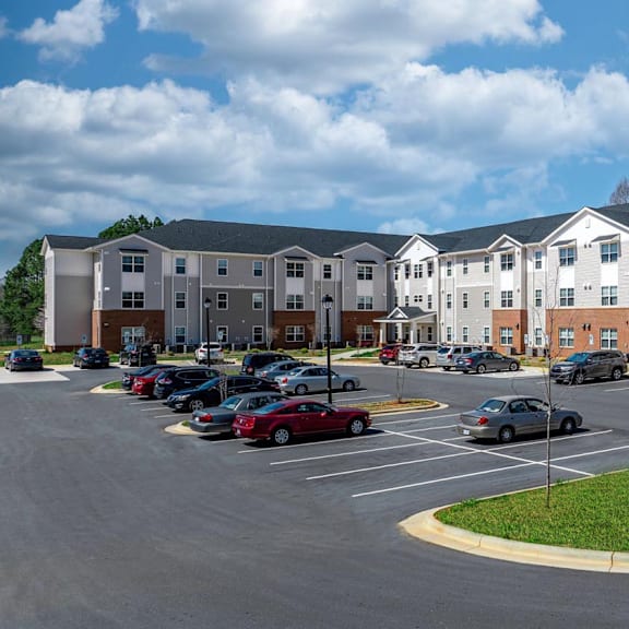 a parking lot with cars in front of an apartment building
