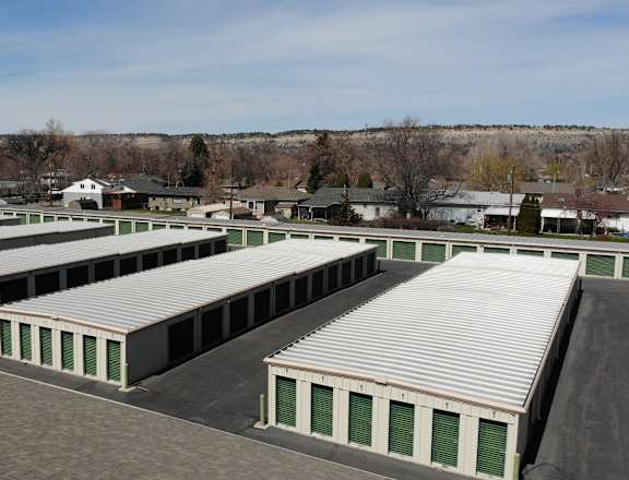 A large storage facility with multiple units and green doors.