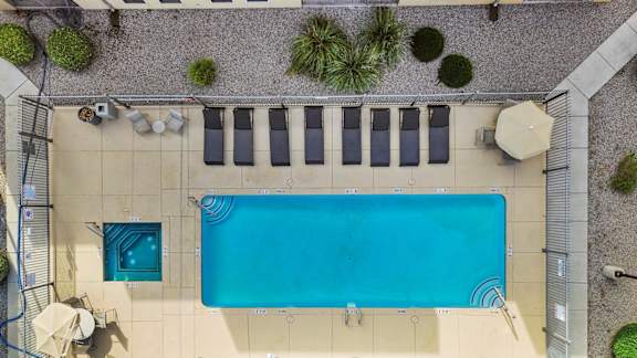 A rectangular pool with a blue tiled border and a white tiled floor.