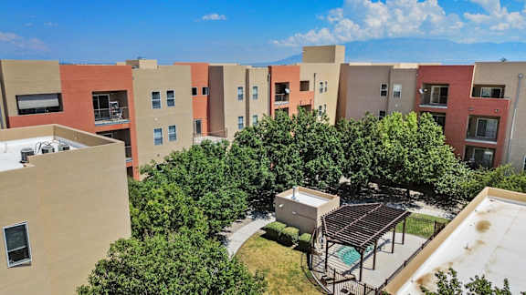 Apartment complex with a pool and trees.