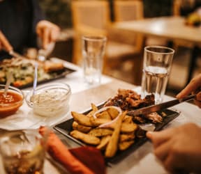 a group of people sitting around a table eating food