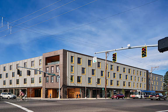 A modern building with a parking lot in front of it.