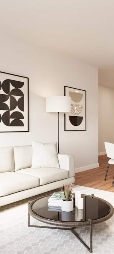 A modern living room with a white couch, wooden chairs, and a coffee table.at The Landing at Hub City, Wisconsin