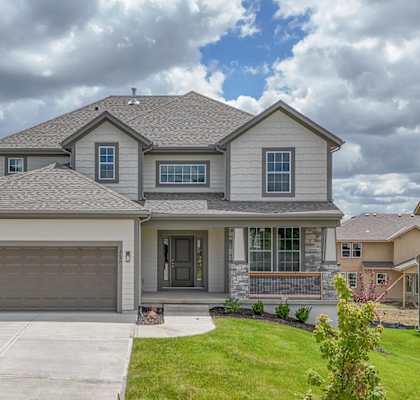 A house with a grey roof and a garage door.