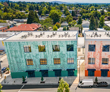 Two buildings with different colored facades are shown from an aerial perspective.
