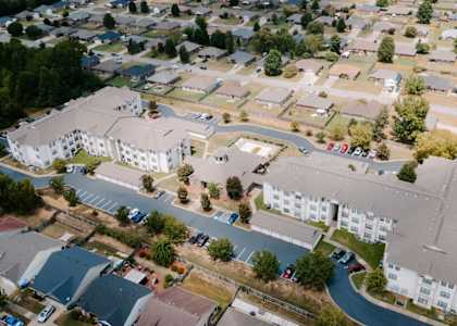 A large white building is surrounded by smaller houses.