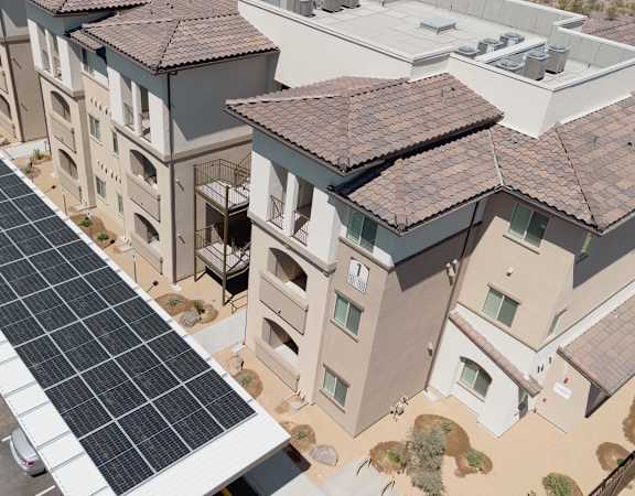A long row of solar panels are installed on the roof of a parking lot.