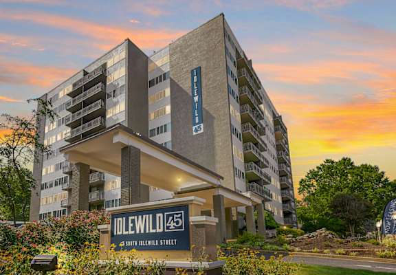 a large apartment building with a sunset in the background