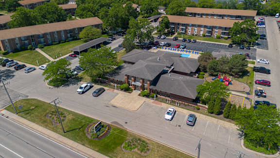 A parking lot with cars and a building in the background.