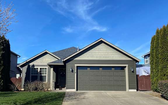 a house with a garage and a blue sky