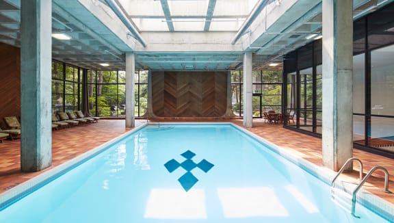 Indoor swimming pool surrounded with loungers.