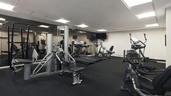 Gym with treadmill, elliptical, stationary bike and weight machines.