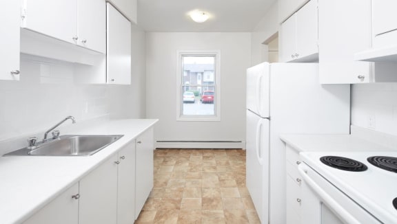Kitchen with white appliances and cabinets.