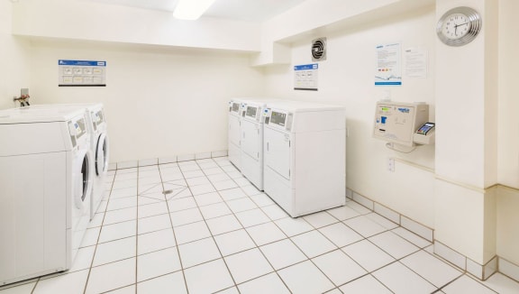laundry area with numerous washers and dryers