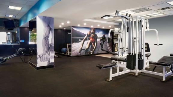 Gym with weight machines and motivational wall graphics.