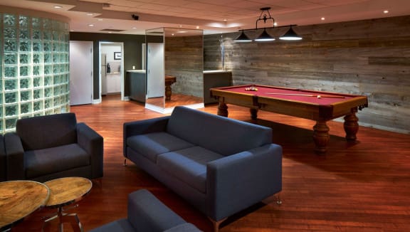 Large social room with seating area, billiards table and kitchenette.