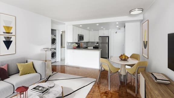 Open concept living and dining room staged with furniture. The kitchen is open from the dining room.