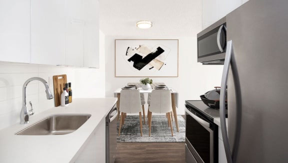 A newly renovated suite with white quartz countertops and stainless steel appliances. Suite finishes may vary, speak to a leasing agent for complete details.