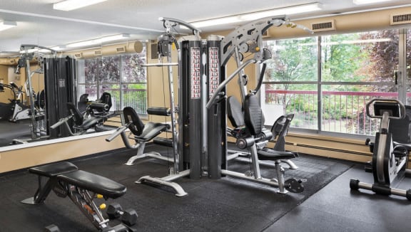 fitness rom with exercise equipment, a large mirror and a window