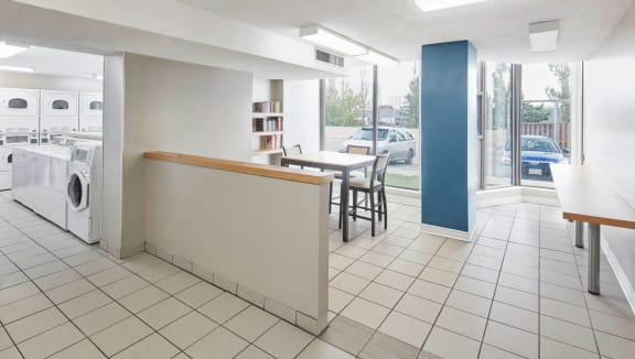 Laundry room with sitting area and bookshelf.