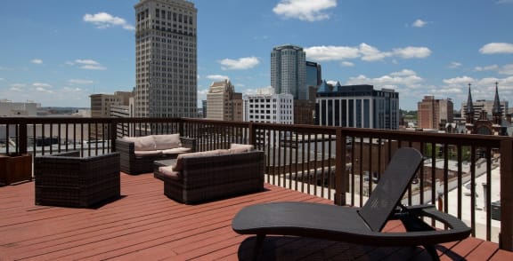 the rooftop deck at Goodall-Brown Lofts with lounging areas and a view of Birmingham, AL's skyline