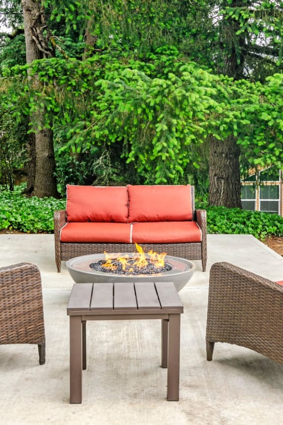 a patio with chairs and a fire pit