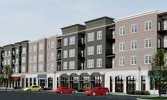 A row of apartment buildings with cars parked in front.
