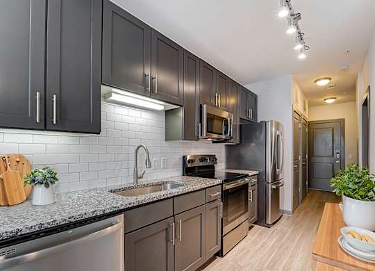 A kitchen with dark brown cabinets and stainless steel appliances.