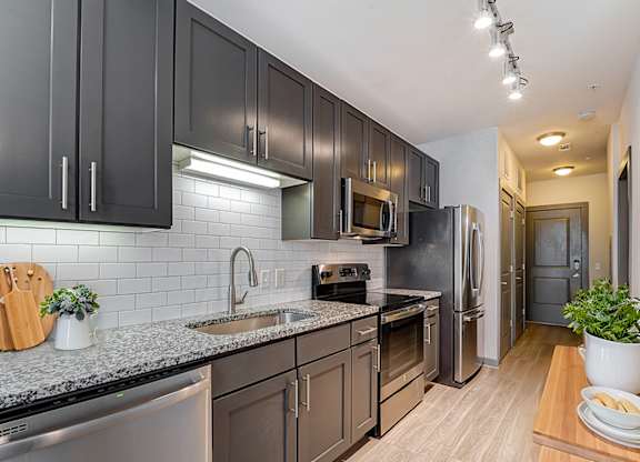 A kitchen with dark brown cabinets and stainless steel appliances.