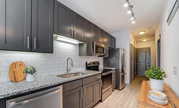 A kitchen with dark brown cabinets and stainless steel appliances.