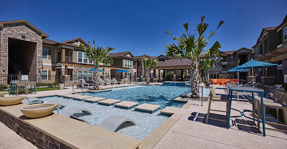 A pool with a slide and a palm tree in the foreground.