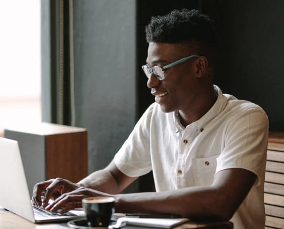 a man sitting at a table using a laptop computer