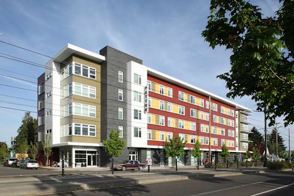 A modern building with a parking lot in front of it.