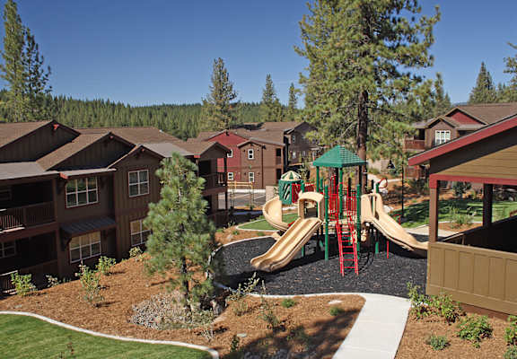 an aerial view of a playground with condos in the background