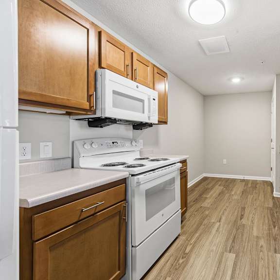 A kitchen with wooden cabinets and white appliances.