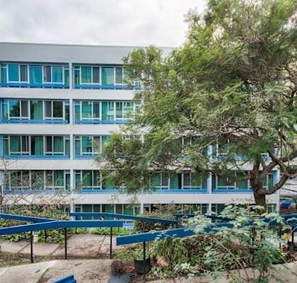 a building with a playground and trees in front of it