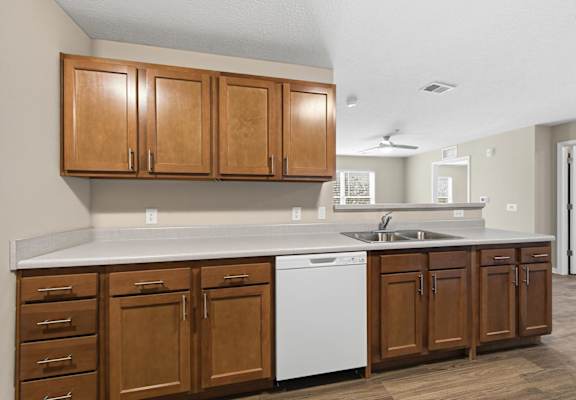 A kitchen with wooden cabinets and a white dishwasher.