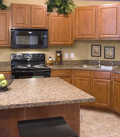 a kitchen with wood cabinets and granite counter tops and black appliances