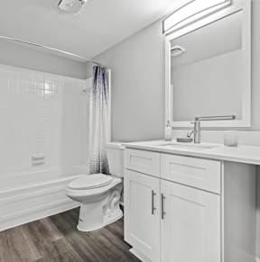 A white bathroom with a toilet, sink, and bathtub.