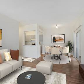 A living room with a grey sofa and a painting on the wall.