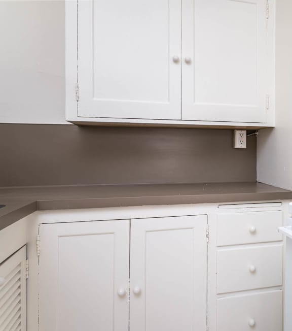 A white kitchen with a stove and cabinets.
