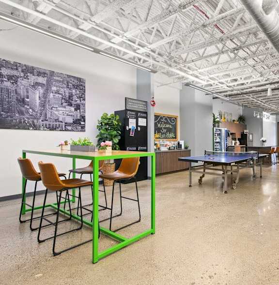 a large room with tables and chairs and a ping pong table